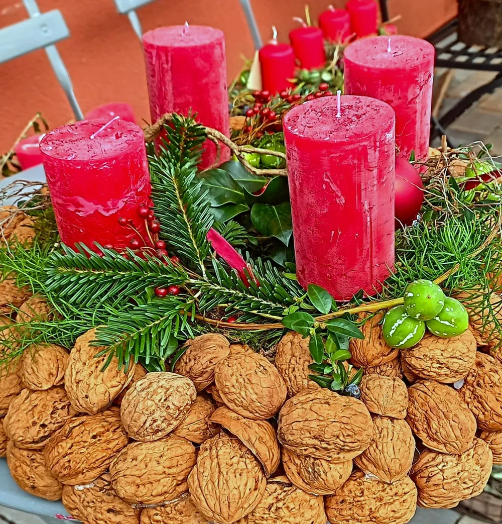 Adventskranz mit roten Kerzen, Tannenzweigen und Walnüssen